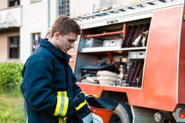 Fototapeta na wymiar depressed and tired firefighter near fire truck. 