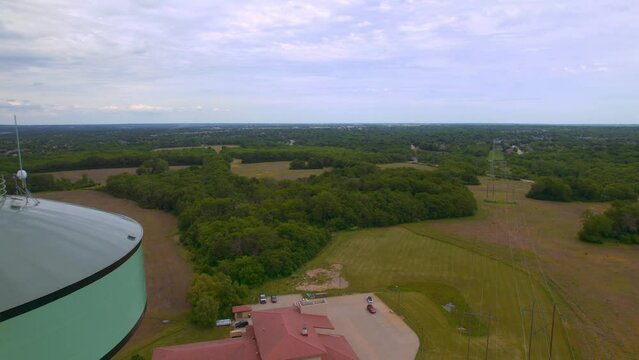 A cool drone fly by shot of a water tower in Lee's Summit Missouri also down below is the fire station