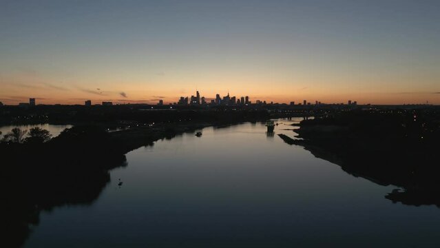 Peaceful river Vistula with the background of Warsaw skyscrapers at dawn. Drone master shot.