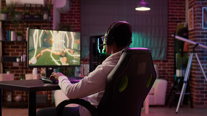 Over shoulder view of gamer streaming multiplayer first person shooter angry after losing online...