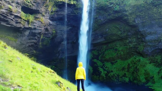 woman standing in front of a beautiful waterfall in iceland