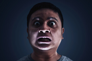 Scared man expression on dark background