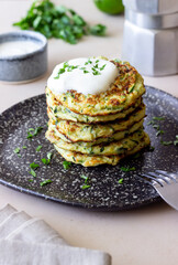Zucchini fritters or pancakes with sour cream and herbs. Healthy eating. Vegetarian food.