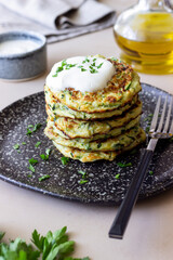 Zucchini fritters or pancakes with sour cream and herbs. Healthy eating. Vegetarian food.