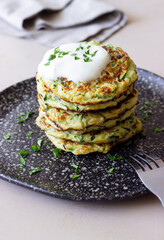 Zucchini fritters or pancakes with sour cream and herbs. Healthy eating. Vegetarian food.