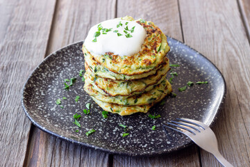 Zucchini fritters or pancakes with sour cream and herbs. Healthy eating. Vegetarian food.