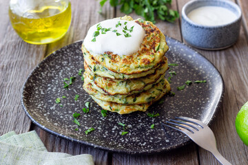 Zucchini fritters or pancakes with sour cream and herbs. Healthy eating. Vegetarian food.