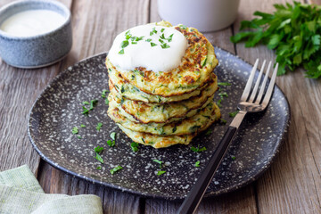 Zucchini fritters or pancakes with sour cream and herbs. Healthy eating. Vegetarian food.