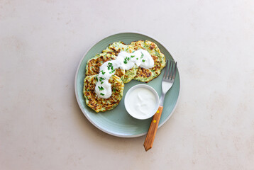 Zucchini fritters or pancakes with sour cream and herbs. Healthy eating. Vegetarian food.