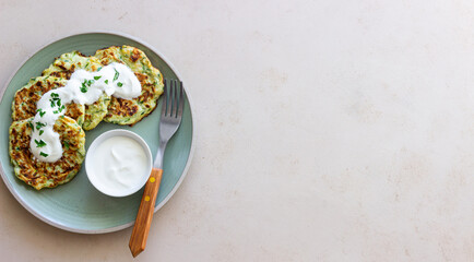 Zucchini fritters or pancakes with sour cream and herbs. Healthy eating. Vegetarian food.