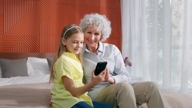 Preteen girl run to grandmother and show picture on smartphone