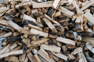 Birch firewood pile texture, split with axe pieces piled in a big heap