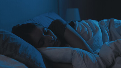 Night sleep. Relaxed woman. Bedtime rest. Tired lady with closed eyes lying in bed in dark home...