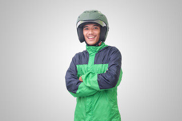 Portrait of Asian online taxi driver wearing green jacket and helmet, standing with crossed arms. Isolated image on white background