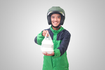 Portrait of Asian online taxi driver wearing green jacket and helmet holding food wrapped in foam plastic box. Isolated image on white background