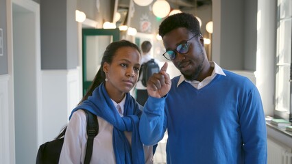 African-American teacher move hand in air explaining subject to schoolgirl