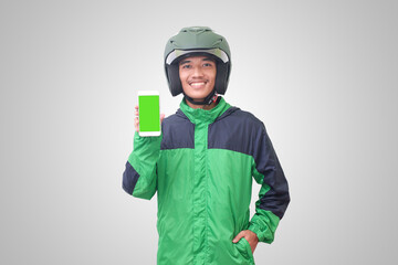 Portrait of Asian online taxi driver wearing green jacket and helmet showing and presenting blank screen mobile phone. Advertising concept. Isolated image on white background