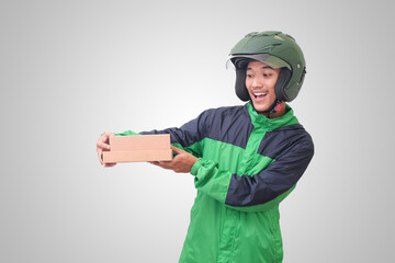 Portrait of Asian online courier driver wearing green jacket and helmet delivering package and box for customer. Isolated image on white background