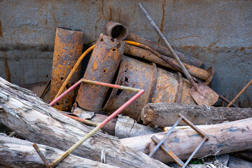 junkyard with rusty metal and tree trunks