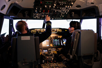 Captain and copilot using dashboard command to takeoff with plane, flying aircraft with control...