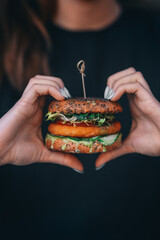 vegan burger in the hands of a woman