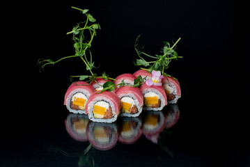 Fototapeta na wymiar sushi on a black with microgreen 