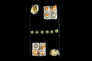 white sushi rolls with list on black background 