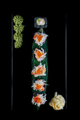 sushi rolls with list on black background 