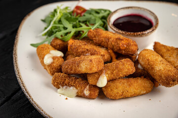 Cheese fries with herbs and sauce on plates on a wooden table
