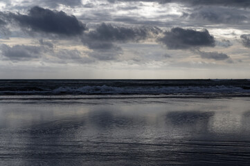 Obraz premium Tide is out, stormy clouds reflected on a wet beach