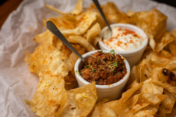 Nachos with sauces on plates on a wooden table
