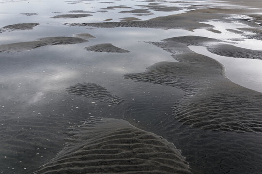 Puddles and undulations in the sand caused by the outgoing tide
