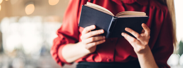 Close-up of woman reading book in big bright open space