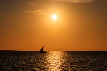 Silhouette of traditional wooden dhow boat in the Indian ocean at sunset in Zanzibar, Tanzania