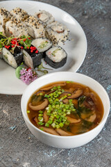 soup with meatballs and sushi rolls