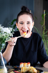 Woman eating sushi.
  A young woman is eating sushi lunch at a Japanese restaurant