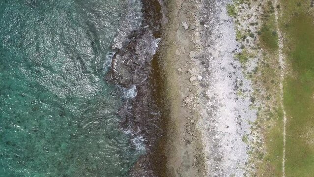drone flying over coral coastline in the caribbean wave crashing.