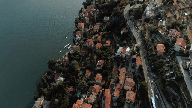 Aerial Bird view tilt over lake come and houses cars roads of Torriggia - moody cinematic