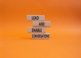 Lead and enable conversations symbol. Concept words Lead and enable conversations on wooden blocks. Beautiful orange background. Business and Lead and enable conversations concept. Copy space.