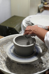 pieza de cerámica moldeándose en torno artesanal de alfarería