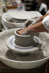 artesano moldeando pieza de cerámica en el torno