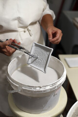 artesano esmaltando pieza de cerámica con herramientas de alfareria 