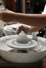 manos de profesional en torno de cerámica artesanal 
