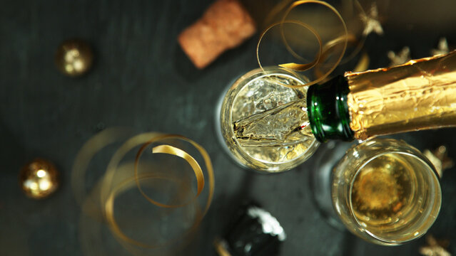 Champagne pouring in a glass from a bottle, top view.