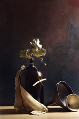 Composizione verticale con bottiglia, imbuti, foglie di quercia; still life su fondo scuro