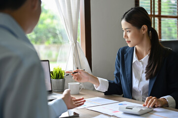Talented Asian female accountant or financial consultant meets with her client