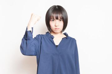 白背景の前に立って、怒っている若い女性