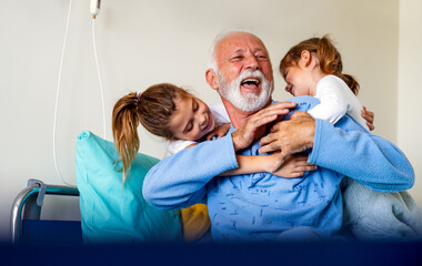 Obraz premium Little girls visiting grandfather in hospital, who is recovering from coronavirus.
