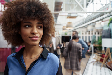 Smiling african businesswoman standing in modern office on colleagues background