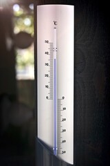 Thermometer in summer shows warm temperatures. 